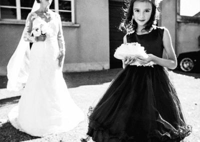 Portrait photo lors d'un mariage, une petite fille pose devant la mariée