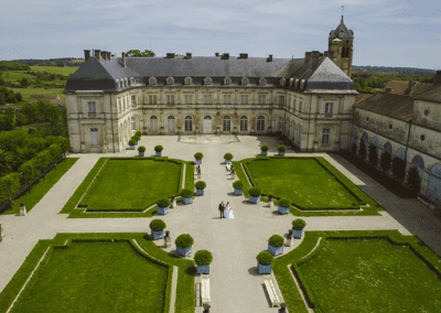 Photo aérienne par drone lors d'un mariage, le couple de mariés se tient au milieu de la cour d'un chateau